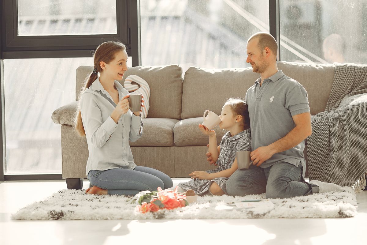 A family shares hot drinks together in the living room
