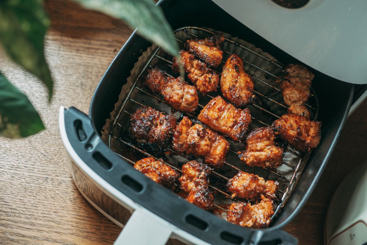 Crispy chicken bites cooking in an air fryer basket