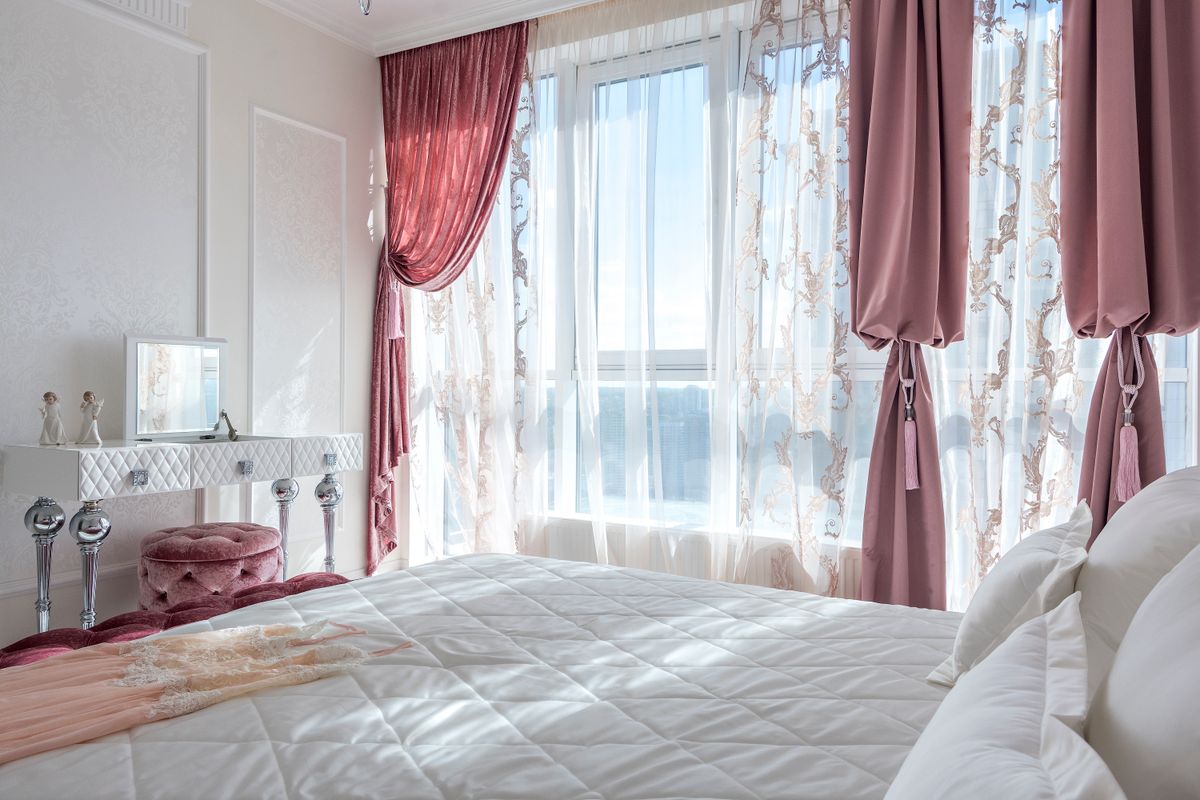 A cozy bedroom with rose-colored curtains