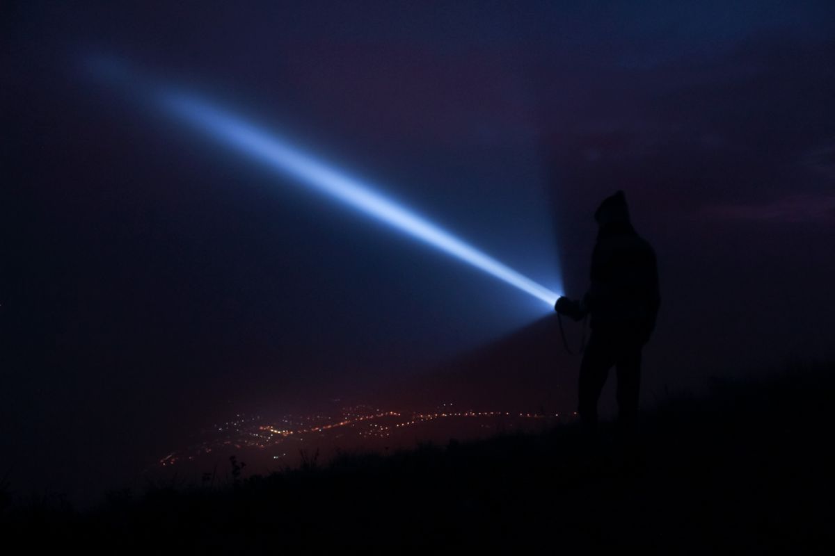 A flashlight beam cutting through the night