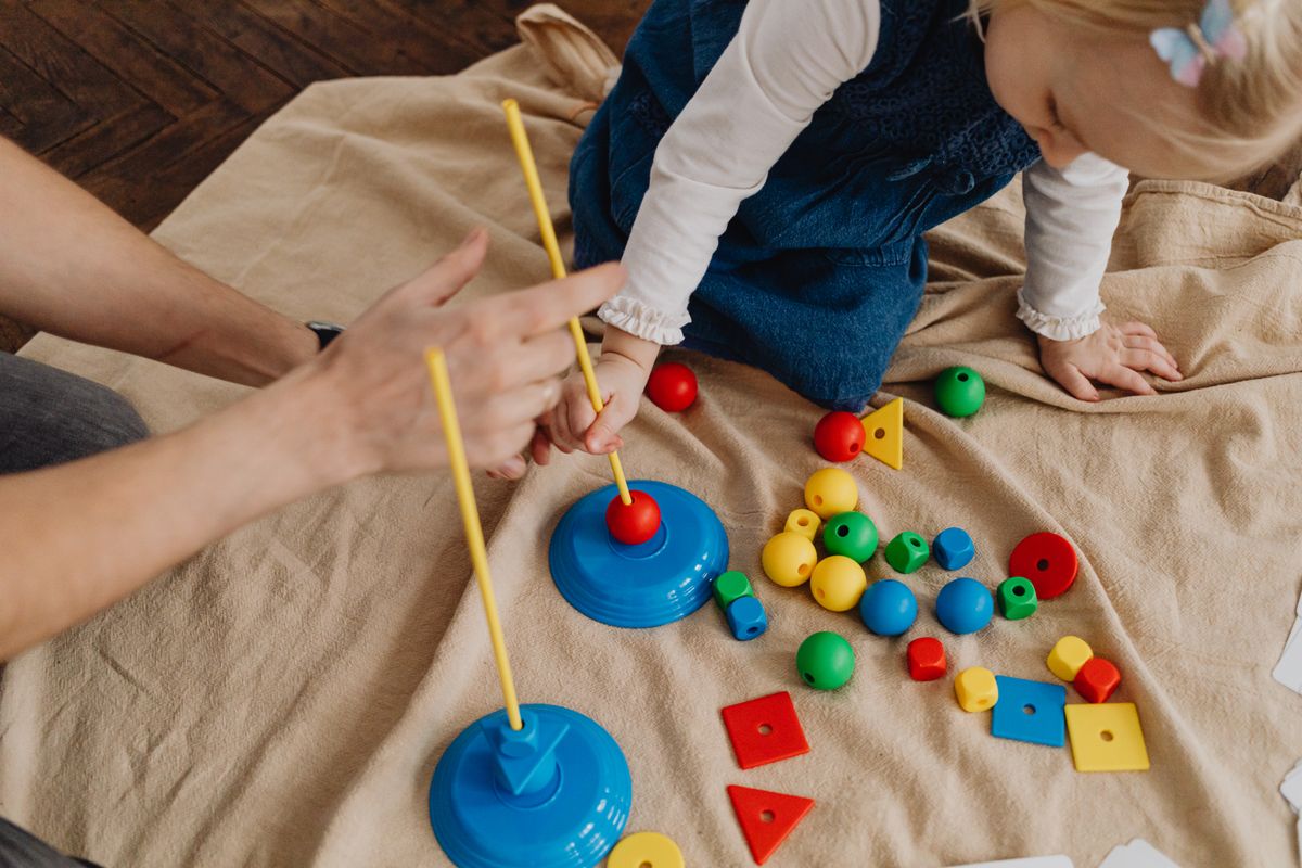 A toddler learning shapes and colors with a parent