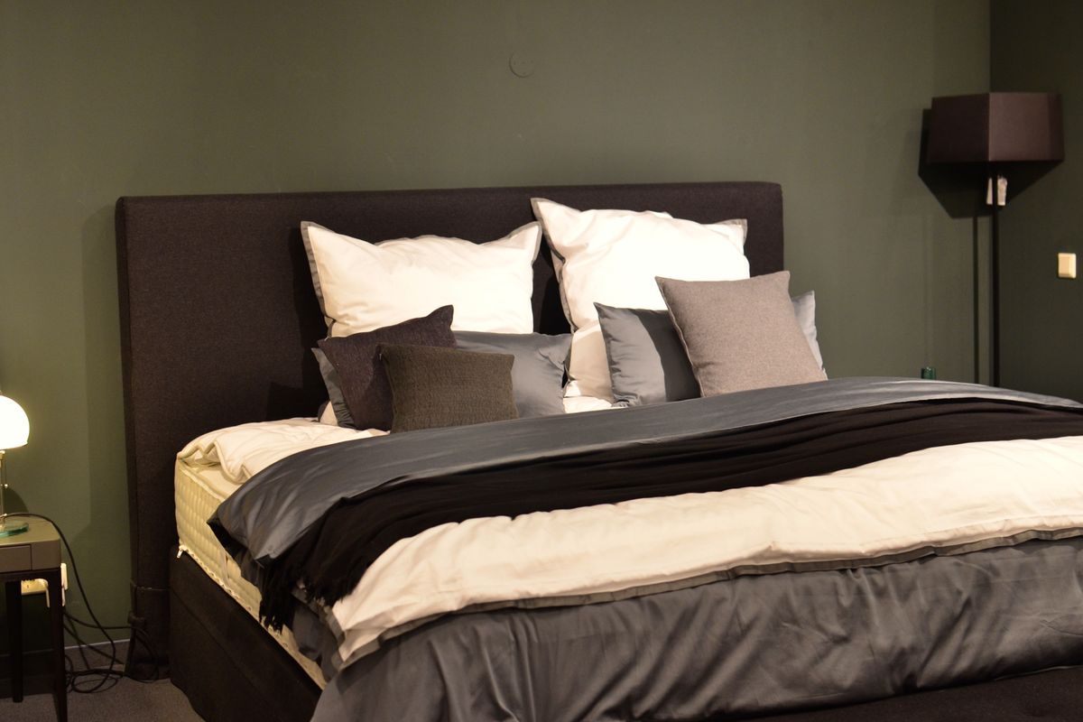 A comfortable made bed with layered pillows